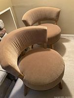 Front left view of both chairs showing round seats, curved backs, and light wood legs.