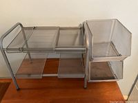 Two silver metal mesh organizers with sliding drawers and open compartments