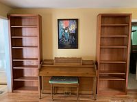 Two tall wood bookcases flanking upright piano in living room