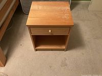 Nightstand front and top view showing wear on the wooden top surface.