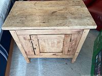 Front view of rustic solid wood side table with visible latch and lock on door.
