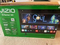 Box of Vizio D-Series 43 Inch TV showing brand, series, and streaming apps on screen image.