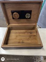 Opened wooden box showing interior wood and lid with embedded humidifier and glass analog hygrometer.