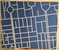 Frontal photo of the stretched and framed canvas showing abstract map street design in blue and gray hues.