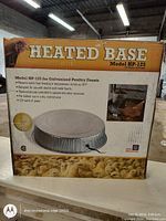 Photo of the packaged heated base Model HP-125 box, showing product details and usage for poultry water containers.