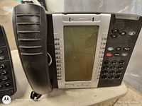 Close-up image showing front side of one corded office telephone with numeric keypad, displayed on a desk