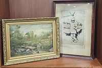 Two framed art pieces: left a gold framed impressionistic landscape painting, right a black & white print of a boy in coat.