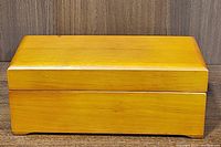 Closed polished wooden display box on wood-grain surface