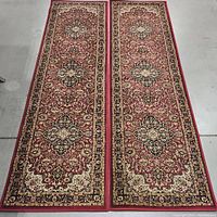 Pair of red medallion runner rugs side by side showing full length and pattern.