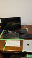 Full lot overview with LG monitor, keyboards, mouse, Apple iPad, and surge protector on desk.