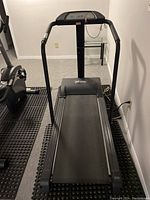 Full view of the Free Spirit treadmill from front showing handrails, control panel, and running belt on black flooring mats.