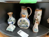 Full group of six Mexican pottery items arranged on a shelf with a visible lot tag.