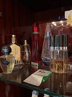 Six assorted opened perfume bottles including Guerlain Shalimar, Calvin Klein ck one, Givenchy ange ou demon, and three others.