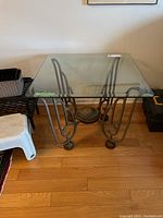 Front full view of the glass top side table showing the square clear glass top and metal base.