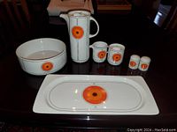 All seven porcelain items arranged on tabletop showing design and scale
