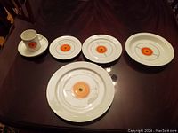 Cup on saucer, side plate, salad plate and dinner plate arranged on table