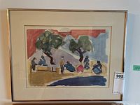 Framed watercolor painting showing abstract figures around trees with a red sky background and blue area foreground.