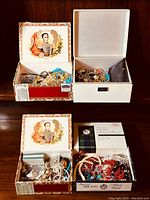 Overview of multiple jewelry-filled boxes including a Cuban cigar box and white small box packed with various jewelry pieces.