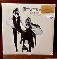 Front cover of sealed Fleetwood Mac Rumours 2011 reissue vinyl LP showing band members in black and white photo with hype sticker.
