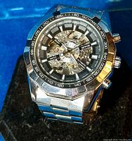 Front view of Sewor men's sport watch with skeleton dial, tachymeter bezel, silver stainless steel construction visible on black display base.