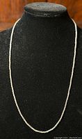 Sterling silver rope chain necklace displayed on black stand, showing full length and shape.
