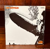 Front cover of Led Zeppelin vinyl LP showing classic zeppelin image in black and white with orange text and ATLANTIC logo.