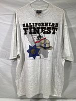 Full front view of the light grey T-shirt with 'CALIFORNIA'S FINEST' text and CHP graphic showing state outline, badge, and hat.