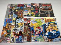 Photo showing all 10 comics laid out in two rows, colorful covers visible, featuring characters such as Ghost Rider, Fantastic Four, Spawn, and others.