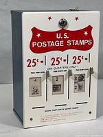 Front view of the vintage U.S. postage stamp dispenser showing the locking mechanism, stamp price and push down levers