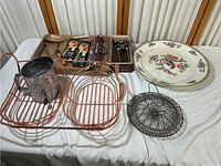 Full view of the collection showing ceramic plate, wire baskets, metal sifter, wire cooling rack and boxed bottle openers.