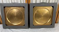 Two gold Charter Club charger plates in original gray boxes side by side, showing the front of packaging and plate design.