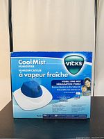 Front of the product box showing Vicks Cool Mist Humidifier branding and features in English and French.