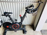 Side view of Echelon Connect indoor exercise bike showing seat, pedals, resistance knob, and handlebar with device stand.