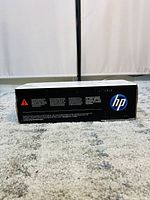 Side view of sealed HP LaserJet 36A toner cartridge box with HP logo and caution text