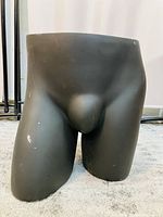 Black male mannequin lower torso and thighs against a light background, front view