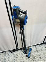 Full view of Shark Rocket Ultra Light corded stick vacuum in upright position showing its overall design, color, and power cord wrapped at the back.