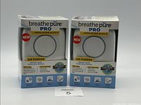Front view of two Breathe Pure Pro air purifier boxes showing branding and features including HEPA filter and UV-C technology.