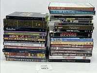 Front view of two stacks of assorted DVDs, Blu-rays, and Xbox 360 games highlighting a variety of movie and game titles.