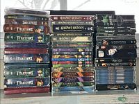 Full collection showing stacked DVD series including Smallville, Hogan's Heroes, Stargate SG-1, The Shield, Supernatural, Angel, and Battlestar Galactica.