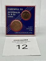 Front view of coin set within protective plastic case showing both coins and blue backing card with labeling.