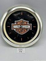 Front view of Harley Davidson wall clock showing logo, clock face, and frame in good condition with minor marks.