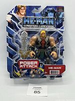 He-Man Power Attack action figure in original blister packaging, showing front view with sword accessory and branded graphics.