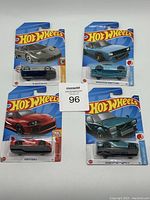 Four Hot Wheels cars in original blister packaging, showing all vehicles and packaging fronts