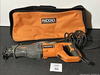 Full view of Ridgid reciprocating saw with power cord and Ridgid branded orange and black carrying case.
