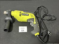 Full side view of the Ryobi electric hammer drill showing body, handle, power cord, and side handle attachment.