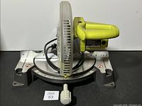 Front view of the Ryobi TS1345L miter saw showing blade and adjustable base with angle measurement.
