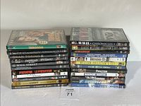 Two stacks of 23 new sealed DVD movie cases arranged on a white surface.