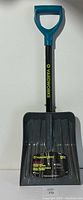 Front view of Yardworks telescopic trunk shovel showing blue D-shaped handle, black shaft with yellow branding, and black shovel scoop with label.