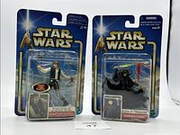 Front view of two Star Wars action figures in sealed packaging: Han Solo and Luminara Unduli.