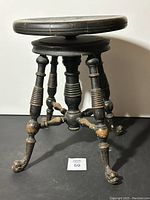 Full side view of the vintage wooden swivel stool with round seat and dragon head feet